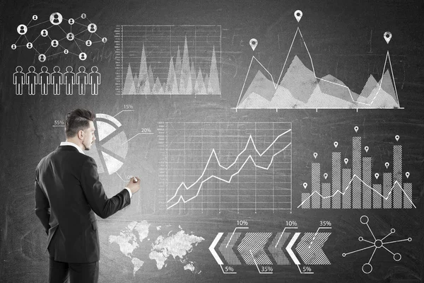 Человек в костюме рисует графики на доске — стоковое фото