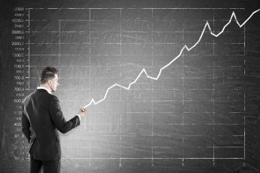 Adam kara tahta üzerinde satış grafiği yapma