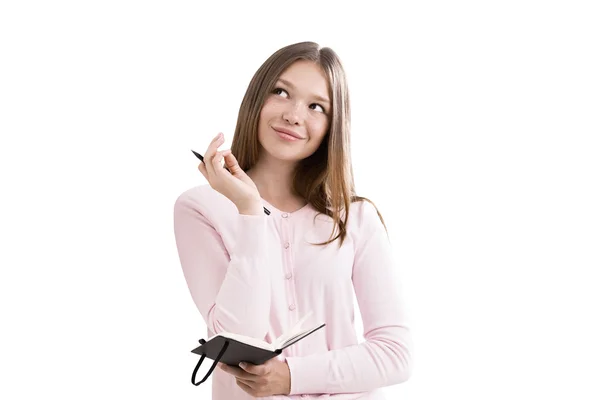 Chica en el cárdigan rosa está de pie y la celebración de su cuaderno y pluma soñando con el futuro brillante. Concepto de sueño grande y se hará realidad. Aislado — Foto de Stock