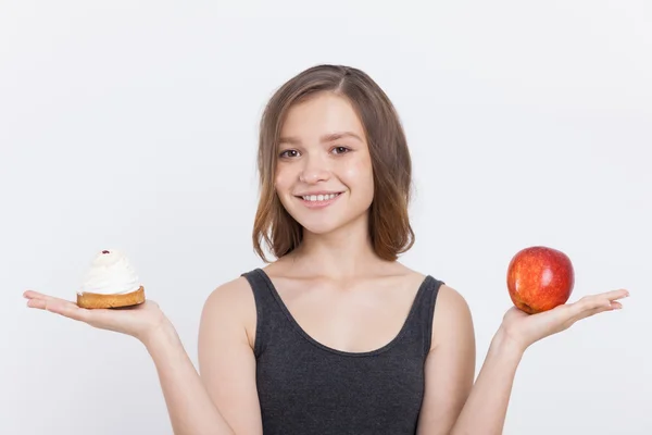 Chica sosteniendo manzana y magdalena —  Fotos de Stock