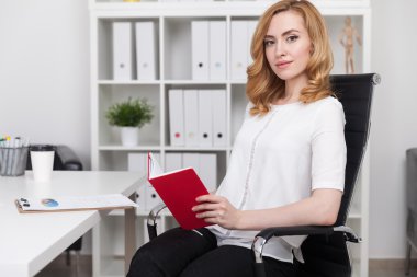 Woman reading book at work