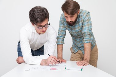 Masanın yanında duran ve projeyi tartışan iki iş arkadaşı. Başarılı başlangıç kavramı