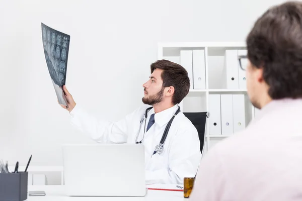 Hersenchirurg kijkt naar x ray beeld van zijn patiënt en probeert hem de juiste diagnose te geven. Concept van nauwgezet doc — Stockfoto