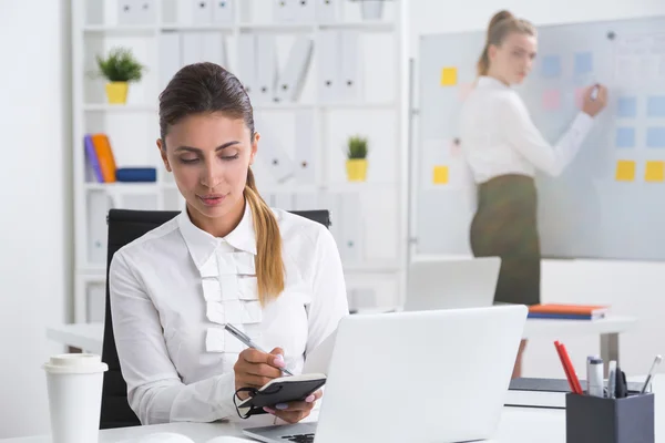 Um gerente-chefe está ditando ao colega o plano de apresentação. Conceito de cooperação e trabalho conjunto — Fotografia de Stock