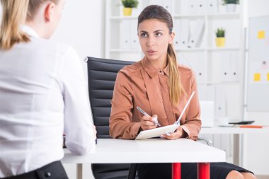 İnsan Kaynakları çalışanı ofisinde yeni aday adayıyla konuşuyor. İşe alım kavramı ve yeni kariyer 