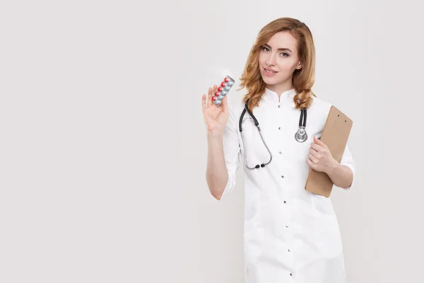 Woman doctor with pills and notepad — Stock Fotó