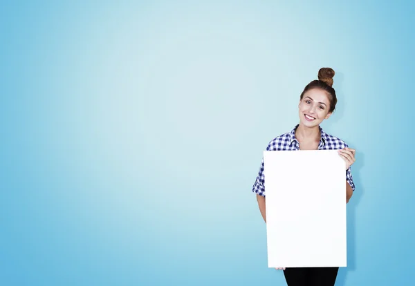 Ragazza in camicia a scacchi con poster vicino al muro blu — Foto Stock