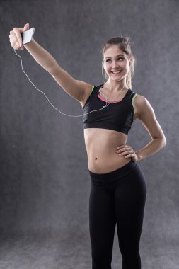 Spor giyimli kız gülümsüyor ve selfie çekiyor