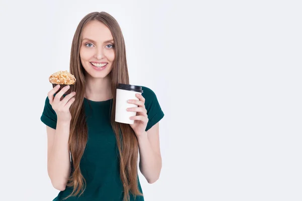 Chica en camiseta verde sosteniendo cupcake y café — Foto de Stock