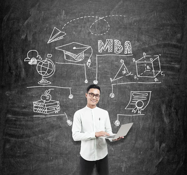 Asian man with laptop and blackboard MBA sketch — Stock Photo, Image