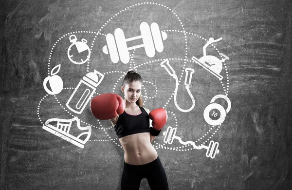 Woman boxer near blackboard with sport icons — Stock fotografie