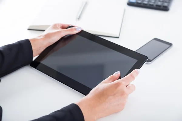 Woman's hands with purple nail polish holding tablet — Stockfoto