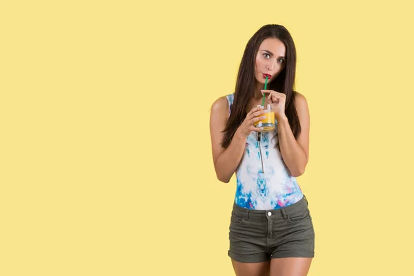 Chica en pantalones cortos bebiendo jugo — Foto de Stock