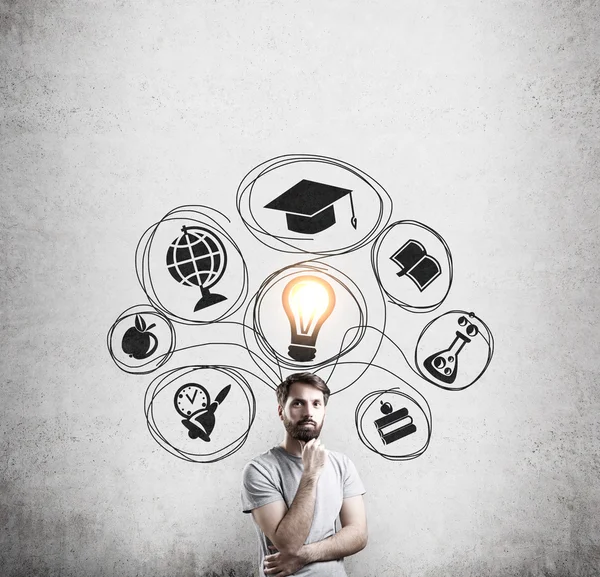 Hombre en camiseta y pared de hormigón con bocetos educativos — Foto de Stock