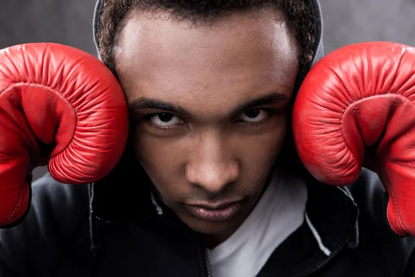 Afro-Américain avec des gants de boxe regardant à la caméra — Photo