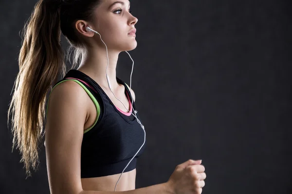 Detailní záběr z koncentrované běžec se sluchátky a smartphone chystá její každodenní trénink. Pojetí fitness maniak — Stock fotografie