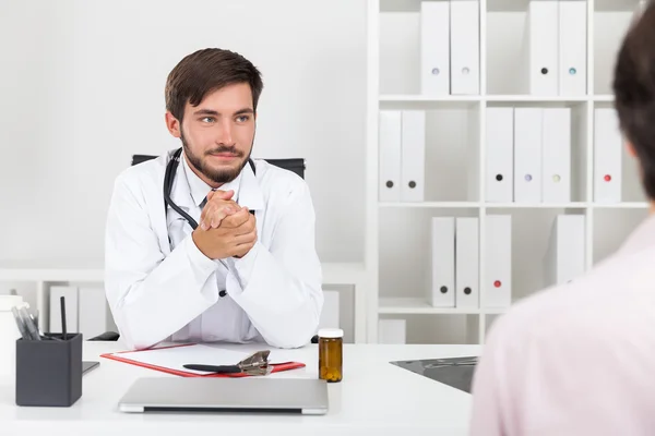 Doctor looking at his patient and rubbing his hands. — Stock Photo, Image