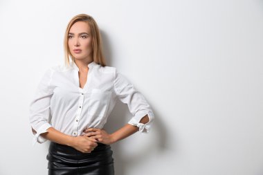 Elleri bel üzerinde duran ve yana doğru seyir biraz sıkılmış iş kadını. Dalgın Bayan iş kavramı. Yukarı alay