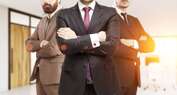 Drie zakenlieden in pakken in een leeg kantoor — Stockfoto