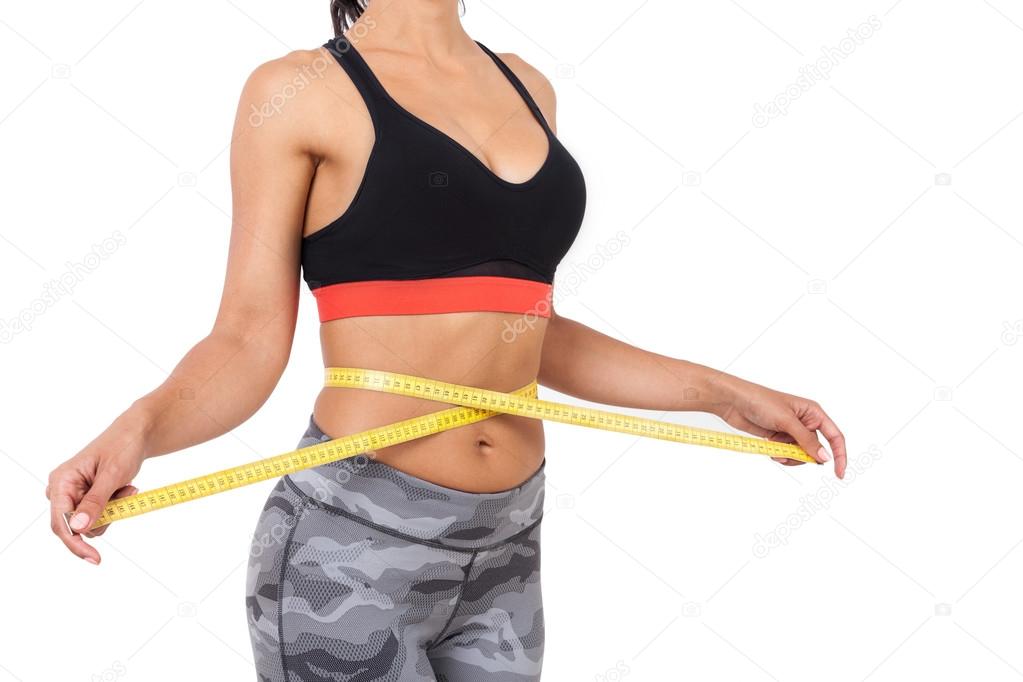 Side view of girl measuring her waist 