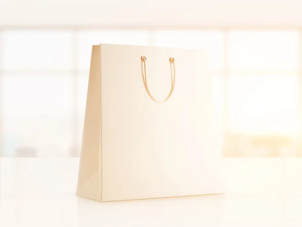 White shopping bag in sunlit office — Stok fotoğraf