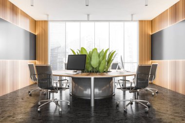 Gri ve ahşap duvarları, beton zemini ve yuvarlak bilgisayar masası olan şık bir açık uzay ofisi. 3d oluşturma