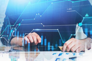 Tanımlanamayan işadamı, bulanık tablet kullanıyor ve mali tableti iki kez gösteriyor. Tonu ayarlanmış resim