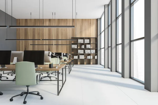 Open space office, tables with computers. Bookshelf with folders near wooden wall. Work space of office, no people, 3D rendering