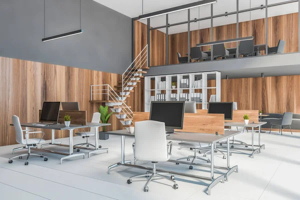 Corner of modern open space office with gray and wooden walls, tiled floor and rows of computer tables. 3d rendering