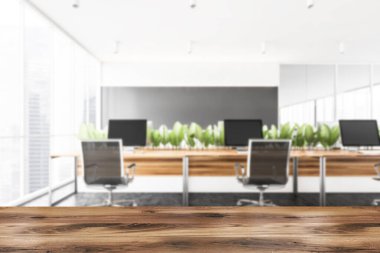 Ürününüz için ahşap masa bulanık modern açık uzay ofisinde beyaz ve gri duvarları, beton zemini ve ahşap bilgisayar masaları olan. 3d oluşturma