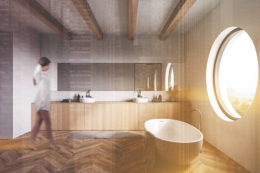 Modern banyoda beyaz duvarları, ahşap zemini, rahat küveti ve çift lavabosu olan bulanık genç bir kadın. Renkli resim çift pozlama