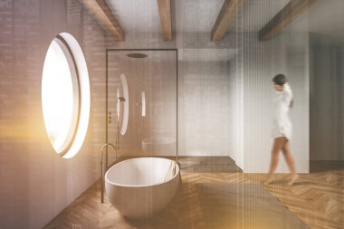 Beyaz duvarları, ahşap zemini, rahat küveti ve duş kabini olan bulanık, genç bir kadın. Renkli resim çift pozlama