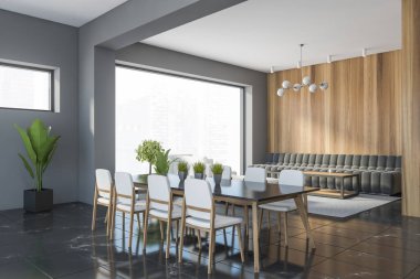 Gri ve ahşap duvarlı şık yemek odasının köşesi, siyah mermer zemin, beyaz sandalyeli uzun masa ve gri kanepe. 3d oluşturma