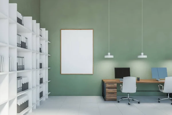 Green office with blank frame mockup and computers on wooden tables, white bookshelf with papers against green wall. Pendant lamps over office desks with white chairs, no people 3D rendering