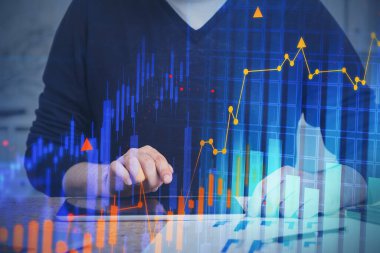 Bulanık ofiste tabletle çalışan tanınmayan genç bir işadamı. Finansal grafiği iki katına çıkarıyor. Tonu ayarlanmış resim