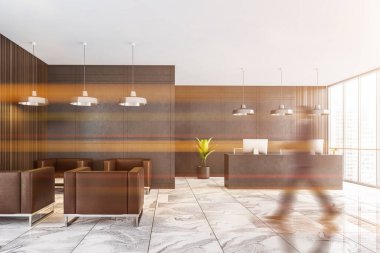 Bulanık genç işadamı gri duvarları, mermer zemini, resepsiyon masası ve gri koltukları olan modern bekleme odasında yürüyor. Tonu ayarlanmış resim