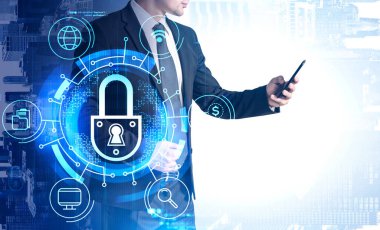 Tanımlanamayan iş adamı bulanık ofiste telefon bilgisayarı kullanıyor ve siber güvenlik arayüzünü iki kez kullanıyor. Tonu ayarlanmış resim