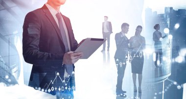 Tanımlanamayan iş adamı bulanık şehirde takım arkadaşlarını iki kez görmüş ve tablet kullanıyor. Tonu ayarlanmış resim