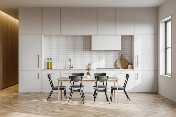 Interior of modern kitchen with white walls, wooden floor, white cupboards and dining table. 3d rendering