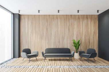 Gri ahşap salon, iki gri koltuk ve uzun kanepe, ahşap duvar ve çakıl döşemeli halı. Minimalist oturma odası, büyük pencereli bir apartman dairesi, hiç insan yok.