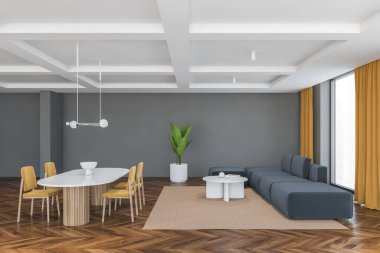 Sarı sandalyeli büyük oturma odası, beyaz masa ve gri kanepe, yan manzara. Büyük salonda büyük pencereler, sarı perdeleri, ahşap parke zemini ve gri duvarları var.