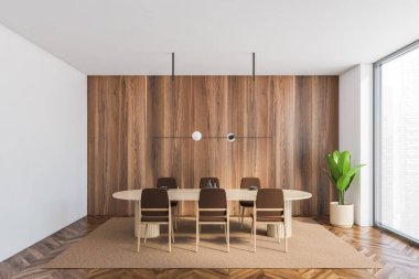 Beyaz ahşap yemek odası, bej oval masa ve büyük pencerenin yanında altı kahverengi sandalye. Kahverengi şık mobilyaları olan minimalist bir oda ve köşede 3 boyutlu bir bitki, insan yok.