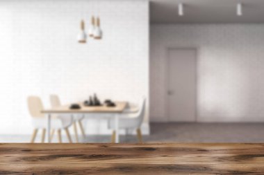 Ürününüz için ahşap masa bulanık modern yemek odasında beyaz ve tuğlalı duvarlar, beton zemin ve beyaz sandalyeli masa. 3d oluşturma