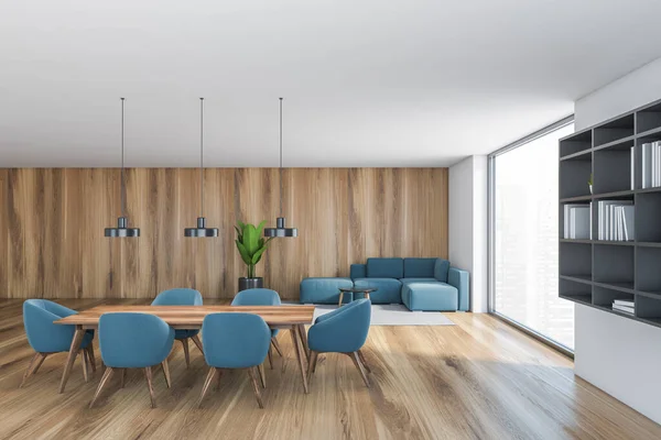 White and wooden hall, blue chairs and table with sofa in the corner near big window. Grey bookshelf and plant in open space hall in modern flat 3D rendering, no people