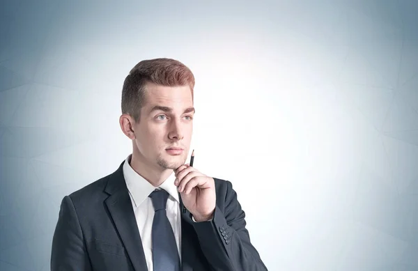Portrait Thoughtful Young Businessman Pen Standing Gray Wall Concept Planning — Stock Photo, Image