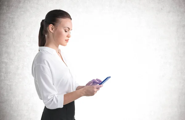 Side Portrait Serious Young Businesswoman Suing Smartphone Concrete Wall Concept — Stock Photo, Image