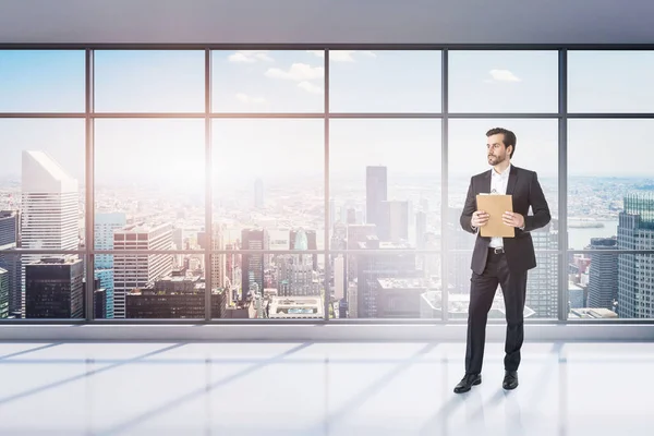 Retrato Joven Hombre Negocios Con Portapapeles Parado Una Oficina Panorámica — Foto de Stock