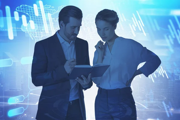 Young businessman and businesswoman talking in blurry city with double exposure of world map and graphs. Toned image. Elements of this image furnished by NASA