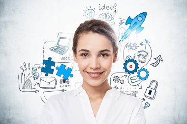 Beton duvarın yanında duran gülümseyen genç bir kadının portresi.