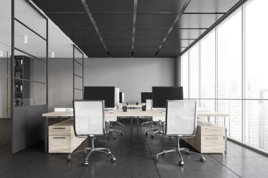 Pencerelerin yanındaki masalarda koltukları ve bilgisayarları olan gri ofis odası. Koyu renk ofis odası, modern ahşap minimalist mobilyalar döşeme döşemesi, 3 boyutlu, kimseyi göstermiyor.